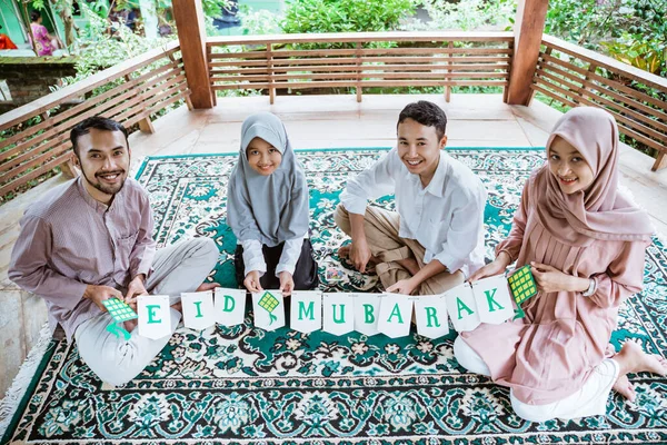 Família muçulmana fazendo decorações de papel no gazebo — Fotografia de Stock