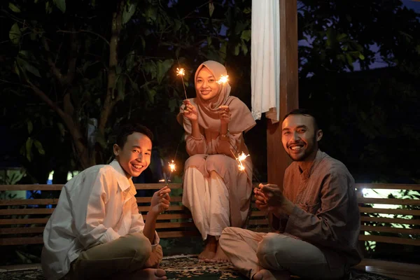 Keluarga merayakan Idul Fitri di malam hari dengan membakar kembang api. — Stok Foto