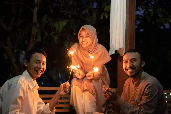 Satu wanita dan dua pria menyalakan kembang api di malam hari — Stok Foto