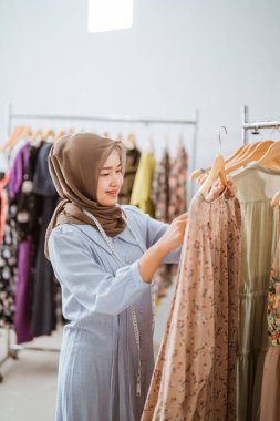 Başarılı Müslüman moda tasarımcısı ürününü kontrol ediyor.
