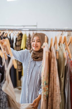 Başarılı Müslüman moda tasarımcısı ürününü kontrol ediyor.