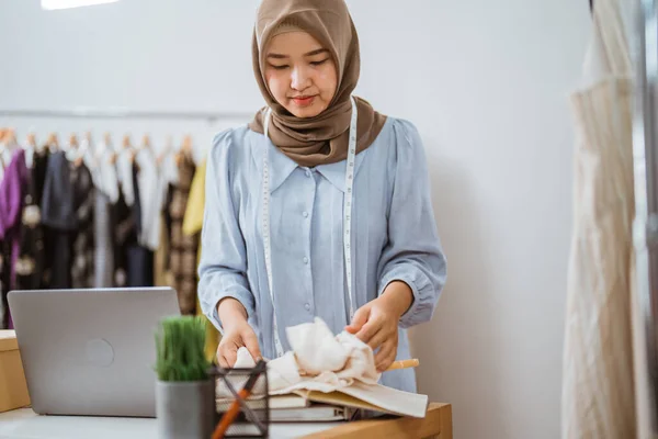 Muslim módní návrhář kontrolu její šaty produkt — Stock fotografie