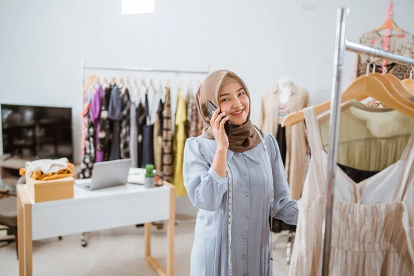 Mulher de negócios muçulmana como designer de moda chamando por telefone — Fotografia de Stock