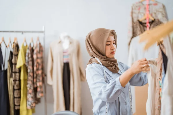 Muslim módní návrhář kontrolu její šaty produkt — Stock fotografie