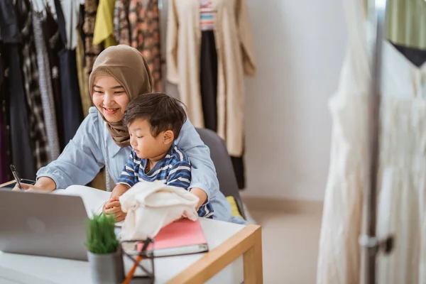 Muslim mother with son are working at her home office — Stock Photo, Image