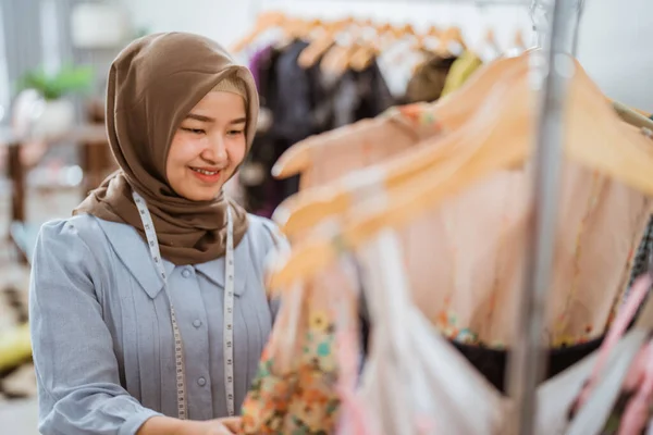 Designer de moda muçulmano bem sucedido verificando em seu produto — Fotografia de Stock