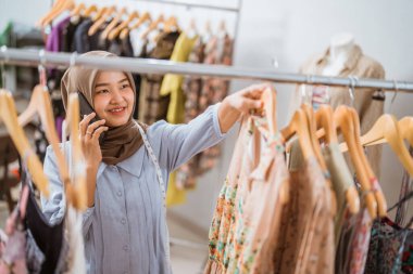 Moda tasarımcısı olan Müslüman iş kadını telefonla arıyor.