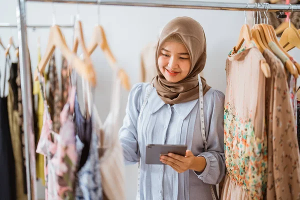 Muszlim divattervező ellenőrzi a ruha termék — Stock Fotó