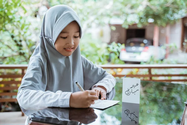 Asiático chica usando un velo haciendo eid mubarak saludo tarjeta —  Fotos de Stock