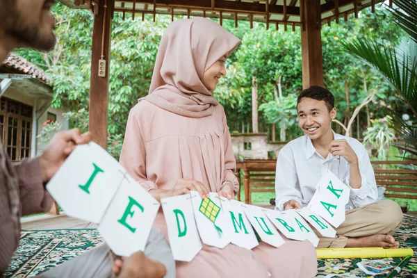 Ibu terselubung, ayah dan anak membuat rantai bendera kertas — Stok Foto