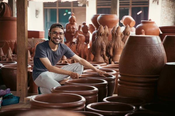 Hombre en vasos sosteniendo cerámica para vender en puesto de artesanía — Foto de Stock