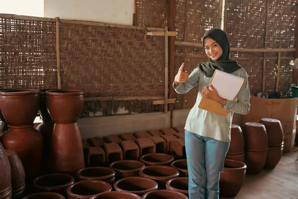 Çömlekçide elinde kağıt olan Müslüman bir iş kadını. — Stok fotoğraf