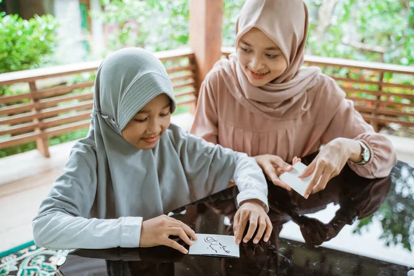 Terselubung ibu dan anak perempuan Asia membuat kartu ucapan eid mubarak — Stok Foto