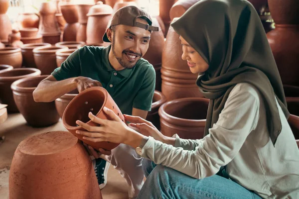 Pengrajin menjelaskan kerajinan tembikar kepada wanita terselubung — Stok Foto