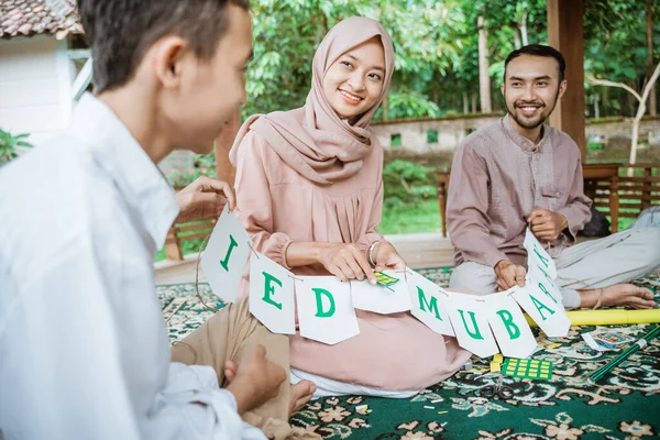 Ayah, ibu dan anak membuat bendera rantai dekorasi kertas bersama-sama — Stok Foto