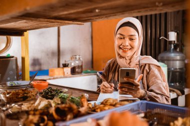 Güzel Müslüman satıcı internetten sipariş alıyor.