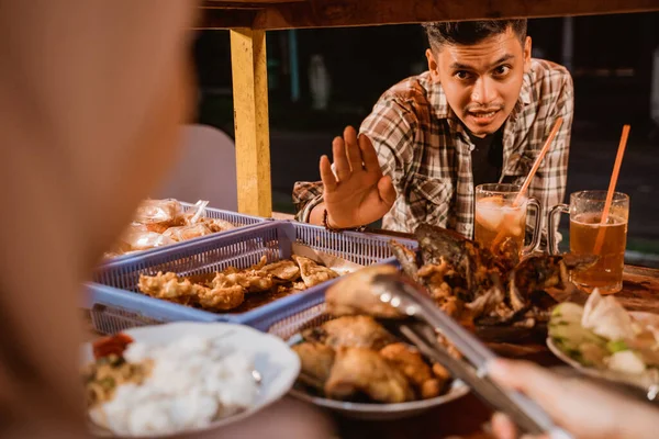 Клиенты мужского пола заказывают еду в небольшом традиционном ларьке — стоковое фото