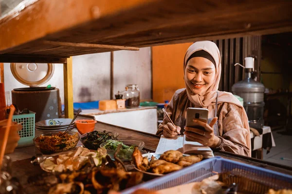 Jovem muçulmano feminino trabalhando como um vendedor de alimentos tradicional — Fotografia de Stock