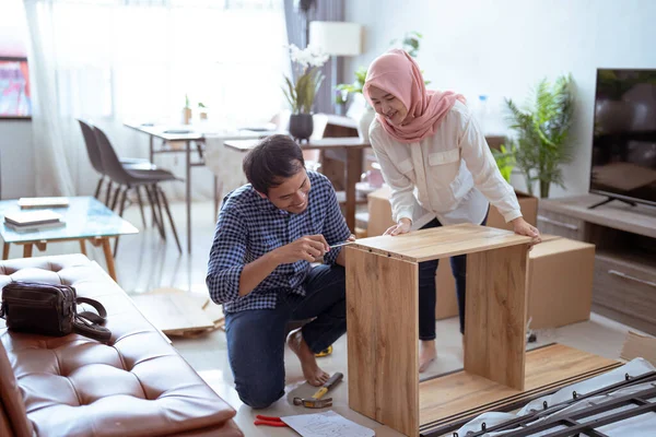 Pareja musulmana ensamblando muebles nuevos juntos en casa — Foto de Stock