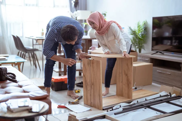 Mladý muslimský pár montážní nábytek doma — Stock fotografie