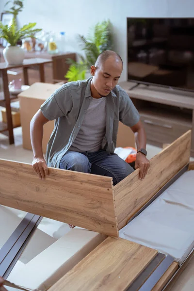 Jovem asiático masculino montagem móveis por si mesmo — Fotografia de Stock
