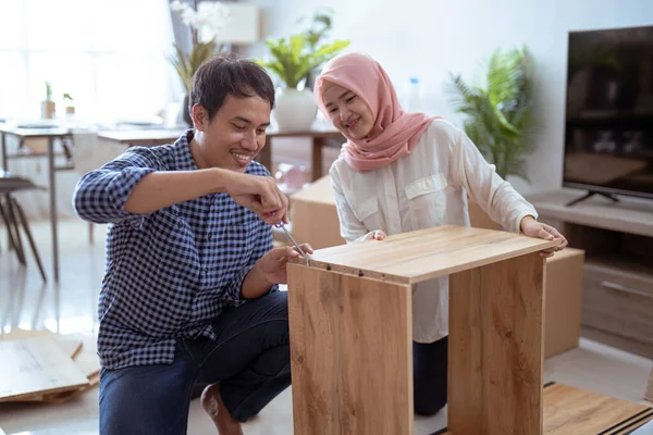 Joven pareja musulmana ensamblando muebles en casa — Foto de Stock