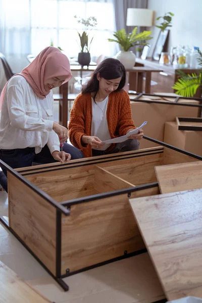 Asiático musulmán mujer y amigo auto montaje nuevo muebles — Foto de Stock