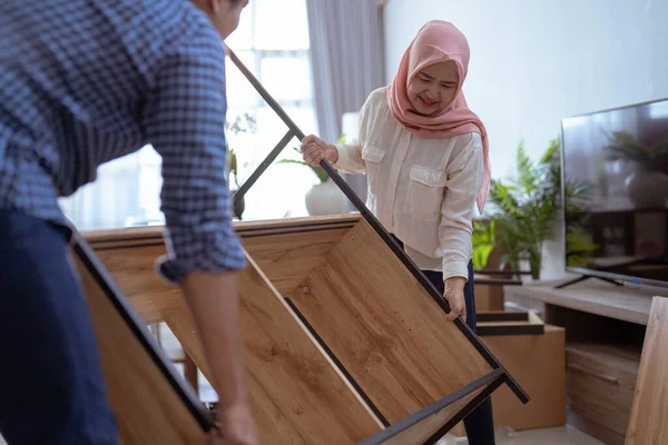 Mujer musulmana tratar tan duro para levantar los muebles nuevos — Foto de Stock