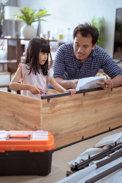 Азіатський батько і дочка збирають нові меблі в своєму будинку — стокове фото