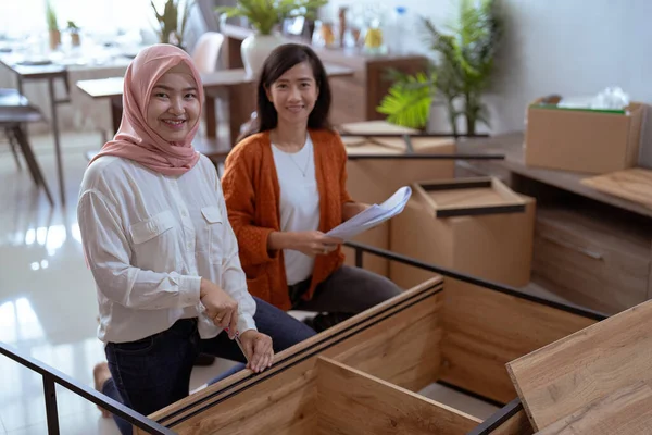 Asiatisk muslimsk kvinna och vän själv montera nya möbler — Stockfoto