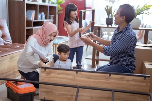 Familia musulmana en su nueva casa comprando y montando nuevos muebles —  Fotos de Stock