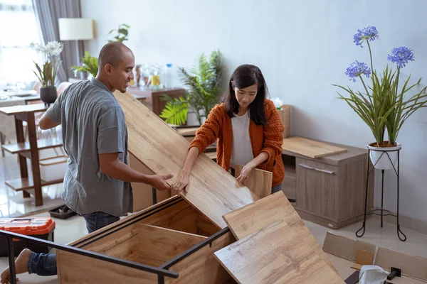 Una pareja feliz mudándose a una casa nueva. Montaje de muebles . — Foto de Stock