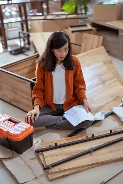Frustrovaná asijské žena při sestavování nového nábytku — Stock fotografie