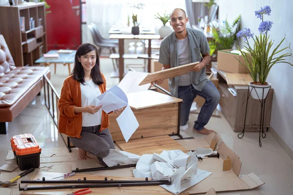 Una pareja feliz mudándose a una casa nueva. Montaje de muebles . — Foto de Stock