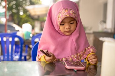 Başörtüsü ile gülümseyen sevimli müslüman genç çocuk.