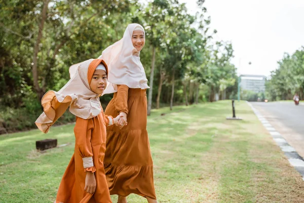 イスラム教徒の母親と娘が一緒に歩いて手を携えて — ストック写真
