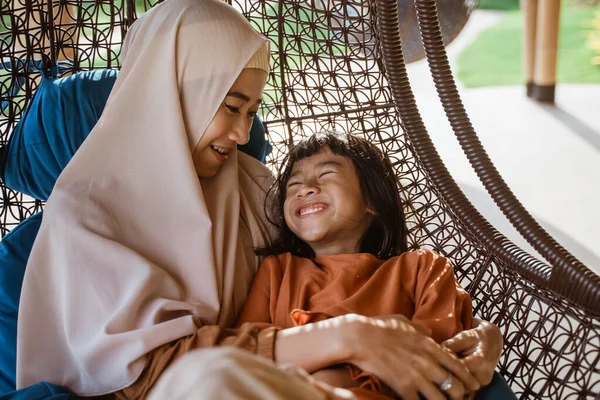 Muslim ibu dan anak duduk dan berpelukan di kursi bersama-sama — Stok Foto