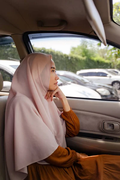 助手席に座って外を見るイスラム教徒の女性 — ストック写真