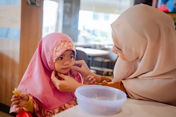 Madre arreglando a sus hijas hijab mientras desayunan — Foto de Stock