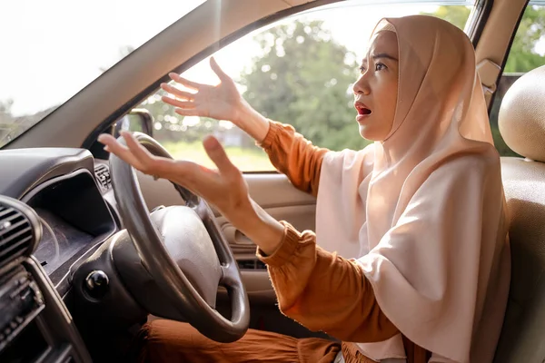 Разочарованная молодая мусульманка за рулём своей машины — стоковое фото