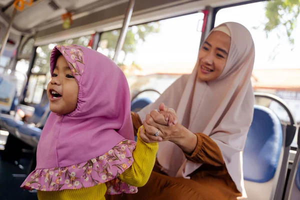 Muslim malá dívka s hidžáb na koni autobus spolu se svou matkou — Stock fotografie