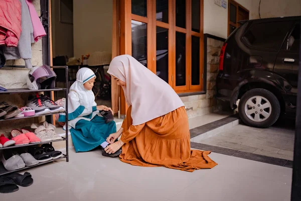 Ibu membantu putrinya untuk meletakkan sepatunya di pagi hari — Stok Foto