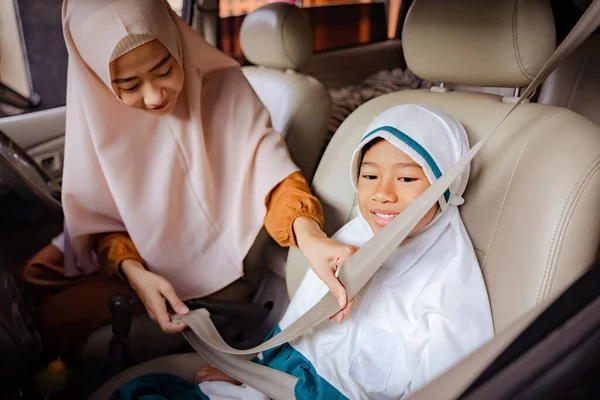 Muçulmano sorrindo mãe levando sua filha para a escola de carro — Fotografia de Stock