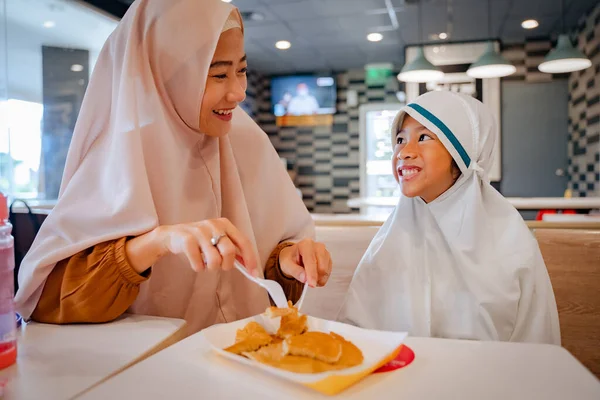 Mãe e filha comendo panqueca. muçulmano asiático família tomando café da manhã — Fotografia de Stock