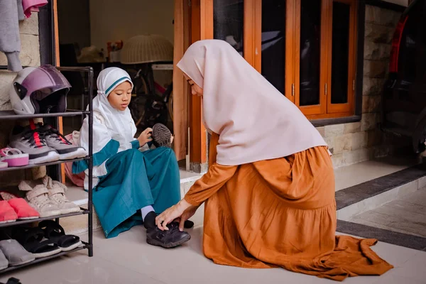 Ibu membantu putrinya untuk meletakkan sepatunya di pagi hari — Stok Foto