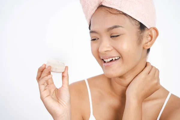 亚洲女孩拿着罐子时使用面部润肤霜 — 图库照片