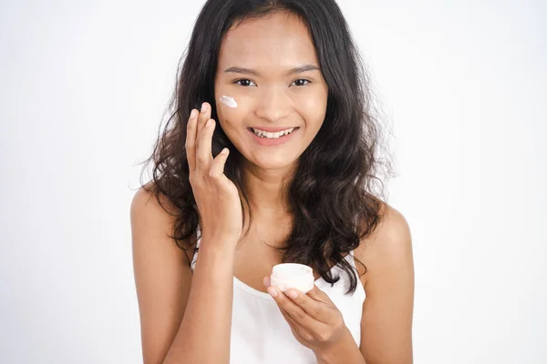 Asiatische Mädchen Anwendung Gesichtsfeuchtigkeitscreme während halten Glas — Stockfoto