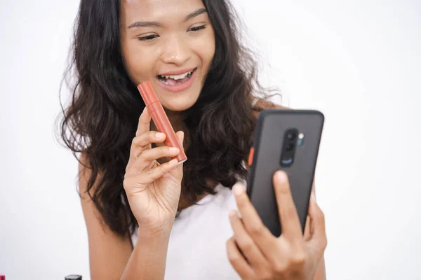 Γυναίκα που δείχνει το προϊόν της στο τηλέφωνο ενώ ηχογραφεί για τα μέσα κοινωνικής δικτύωσης — Φωτογραφία Αρχείου