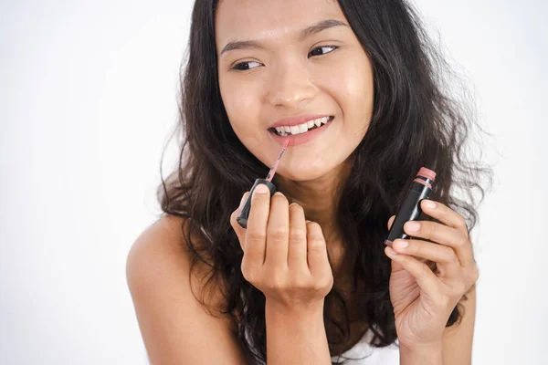 Woman applying lipstick on her lip on white background — Stock Photo, Image