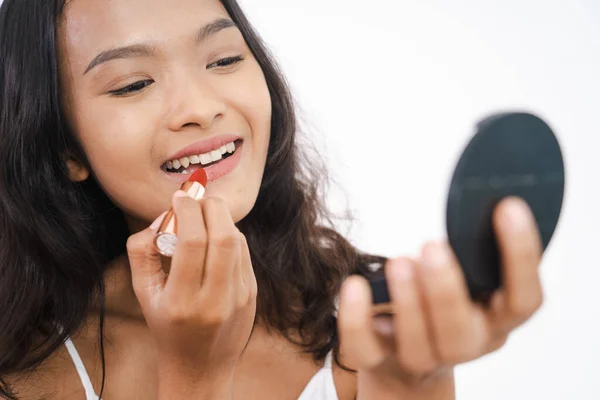 Mujer aplicando lápiz labial en su labio sobre fondo blanco —  Fotos de Stock